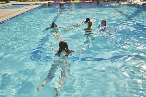 Freunde schwimmen zusammen im Pool an einem sonnigen Tag im Urlaub - ANNF00438