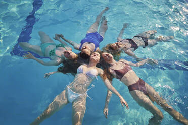 Glückliche Freunde schwimmen zusammen im Pool - ANNF00460