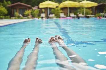 Legs of woman swimming in pool at resort - ANNF00465