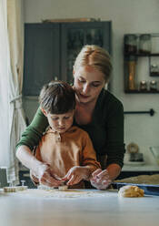 Mutter und Sohn bereiten in der Küche Lebkuchen vor - VSNF01336