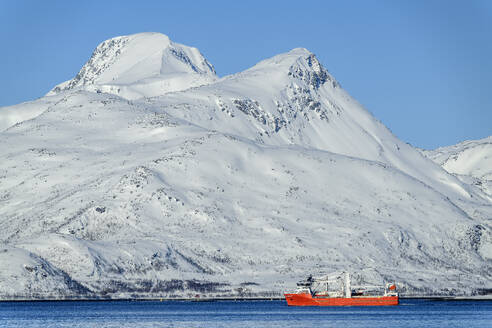Norwegen, Troms og Finnmark, Joviknes, Trawler fährt an schneebedecktem Berg vorbei - ANSF00558