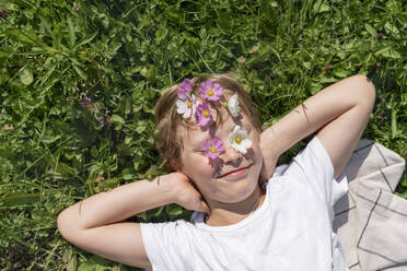 Glücklicher Junge mit Blumen auf der Stirn und Augen an einem sonnigen Tag - VBUF00366