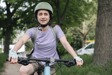 Lächelnde Frau hält den Griff eines Fahrrads - AMWF01662