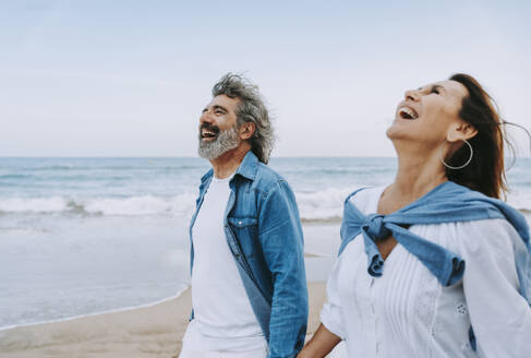 Senior couple laughing and enjoying weekend at beach - OIPF03391