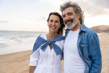 Lächelndes heterosexuelles Paar am Strand am Wochenende - OIPF03392