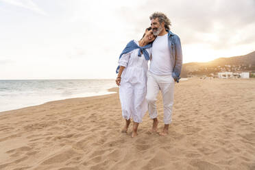 Heterosexual couple standing on sand by sea - OIPF03394