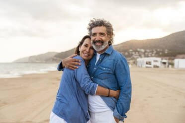 Smiling heterosexual couple hugging at beach - OIPF03404