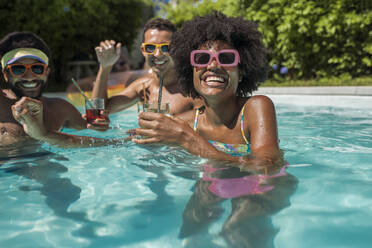 Fröhliche Freunde bei der Poolparty im Resort - VRAF00170