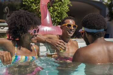 Fröhliche Freunde genießen die Poolparty an einem sonnigen Tag im Resort - VRAF00173
