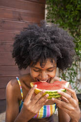 Fröhliche Frau isst Wassermelone im Urlaub - VRAF00185