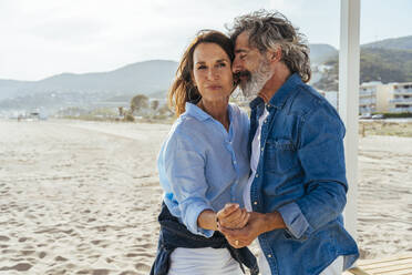 Senior man with eyes closed dancing with woman at beach - OIPF03460