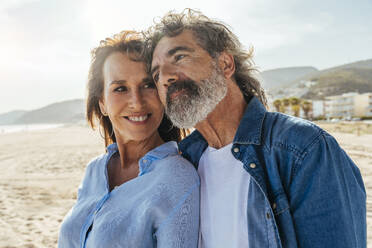 Thoughtful senior man with smiling woman at beach on weekend - OIPF03466