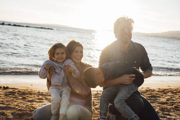 Glücklicher Vater und Mutter spielen mit Kindern am Strand - JOSEF20607