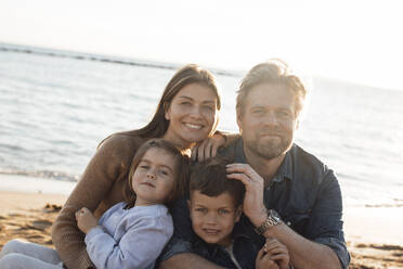 Smiling mother and father with children in front of sea - JOSEF20608