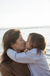 Mutter küsst Tochter auf den Mund am Strand - JOSEF20611