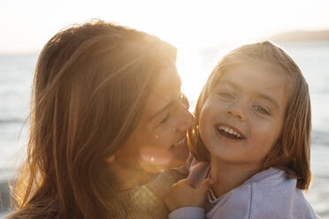 Cheerful mother and daughter enjoying at beach - JOSEF20638