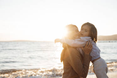 Tochter umarmt Mutter am Meer am Strand - JOSEF20642