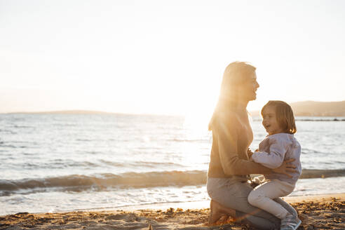 Mother and daughter spending leisure time at beach - JOSEF20643