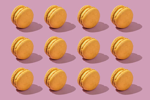 Yellow macaroons arranged on pink background - FLMF01005