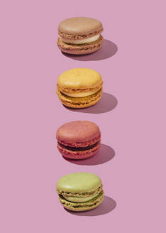 Colorful macaroons in a row on pink background - FLMF01019