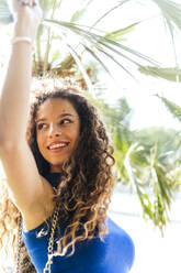 Happy young woman with long curly hair - PBTF00223