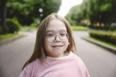 Smiling girl with eyeglasses in park - EYAF02721