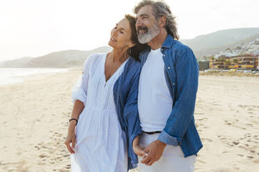 Lächelnder Mann und Frau stehen zusammen am Strand - OIPF03496