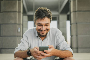 Smiling man using smart phone - ANAF02049