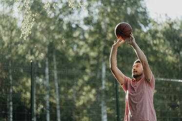 Mann spielt Basketball auf einem Spielplatz - ANAF02052