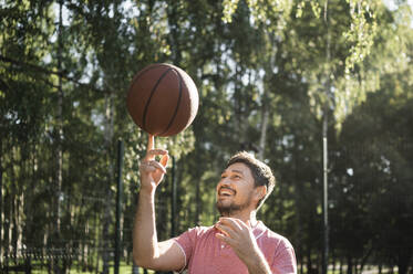 Glücklicher Mann beim Basketballspielen im Gericht - ANAF02057