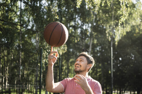 Glücklicher Mann beim Basketballspielen im Gericht - ANAF02057