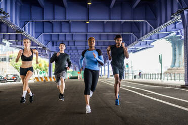 Multi-ethnic group of runners training outdoors - Sportive people running on the street of Manhattan, concepts about sport and healthy lifestyle - DMDF03871