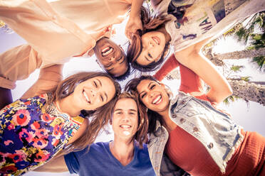 Multicutural group of young people having fun on a tropical beach - Friends on a summer holiday looking down at camera and laughing - DMDF03875