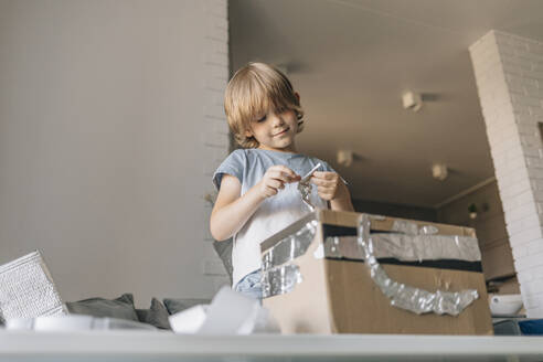 Blond boy making astronaut suit at home - EVKF00004