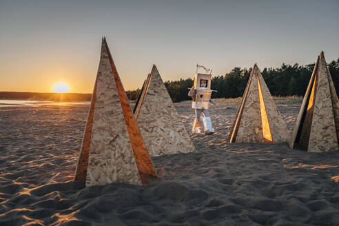 Junge im Astronautenanzug bei futuristischen Zelten im Sand am Strand - EVKF00032