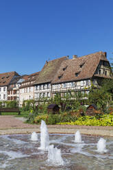 Frankreich, Grand Est, Wissembourg, Springbrunnen mit Fachwerkhäusern im Hintergrund - GWF07905