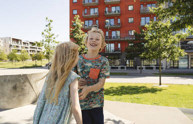 Glücklicher Bruder spielt mit Schwester auf dem Spielplatz - IHF01612