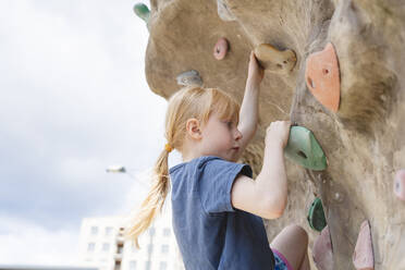 Girl climbing rock wall at playground - IHF01619