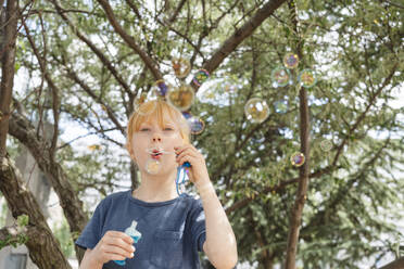 Cute girl blowing soap bubbles - IHF01620