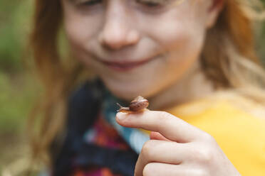 Mädchen mit kleiner Schnecke am Finger - IHF01643