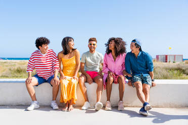 Multiethnic group of young happy friends bonding outside, having fun on summertime vacation - Multicultural cheerful people with summer clothes enjoying summer holidays, concepts about youth, friendship and positive emotion - DMDF03901
