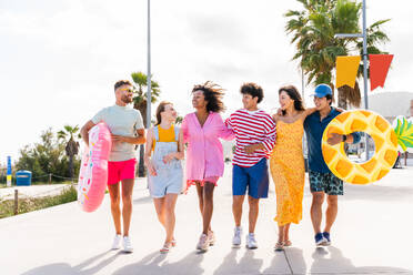 Multiethnic group of young happy friends bonding outside, having fun on summertime vacation - Multicultural cheerful people with summer clothes enjoying summer holidays, concepts about youth, friendship and positive emotion - DMDF03908