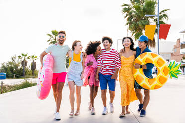 Multiethnic group of young happy friends bonding outside, having fun on summertime vacation - Multicultural cheerful people with summer clothes enjoying summer holidays, concepts about youth, friendship and positive emotion - DMDF03909