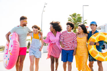 Multiethnic group of young happy friends bonding outside, having fun on summertime vacation - Multicultural cheerful people with summer clothes enjoying summer holidays, concepts about youth, friendship and positive emotion - DMDF03910