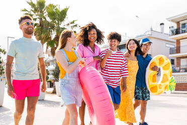 Multiethnic group of young happy friends bonding outside, having fun on summertime vacation - Multicultural cheerful people with summer clothes enjoying summer holidays, concepts about youth, friendship and positive emotion - DMDF03911