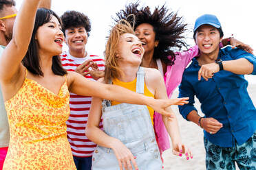 Multiethnic group of young happy friends bonding outside, having fun on summertime vacation - Multicultural cheerful people with summer clothes enjoying summer holidays, concepts about youth, friendship and positive emotion - DMDF03926