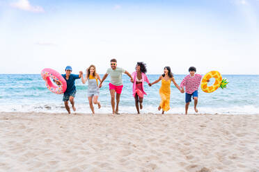 Multiethnic group of young happy friends bonding outside, having fun on summertime vacation - Multicultural cheerful people with summer clothes enjoying summer holidays, concepts about youth, friendship and positive emotion - DMDF03931