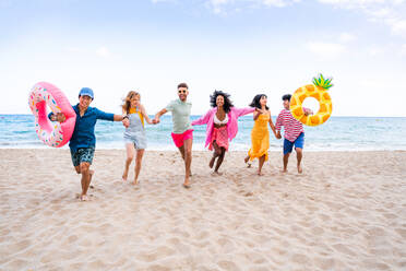 Multiethnic group of young happy friends bonding outside, having fun on summertime vacation - Multicultural cheerful people with summer clothes enjoying summer holidays, concepts about youth, friendship and positive emotion - DMDF03932