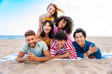 Multiethnic group of young happy friends bonding outside, having fun on summertime vacation - Multicultural cheerful people with summer clothes enjoying summer holidays, concepts about youth, friendship and positive emotion - DMDF03939