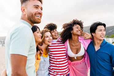 Multiethnic group of young happy friends bonding outside, having fun on summertime vacation - Multicultural cheerful people with summer clothes enjoying summer holidays, concepts about youth, friendship and positive emotion - DMDF03946